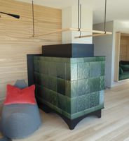 Grüner moderner Ofen als Kombiofen mit gemauerten Zügen. Dieser moderne Kaminofen wurde gestaltet für BauFritz